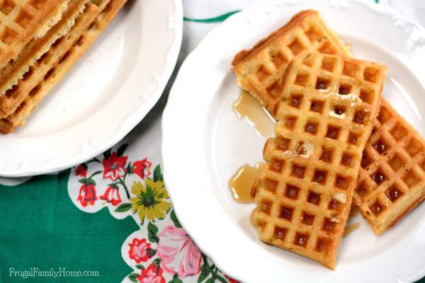 Homemade waffles on a plate with butter and syrup.