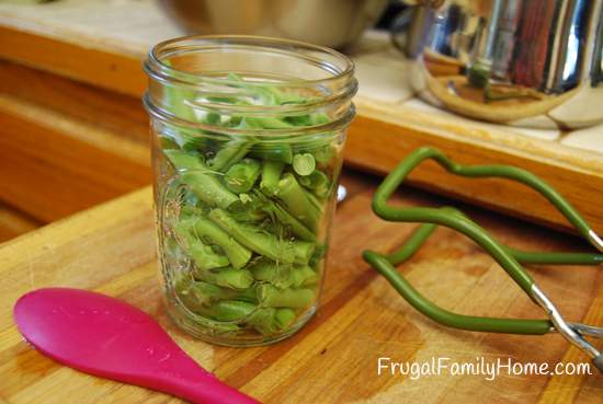 Green beans in jar on cutting board