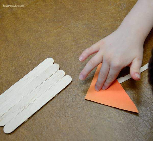 Adding the sail to our popsicle stick raft  | Frugal Family Home