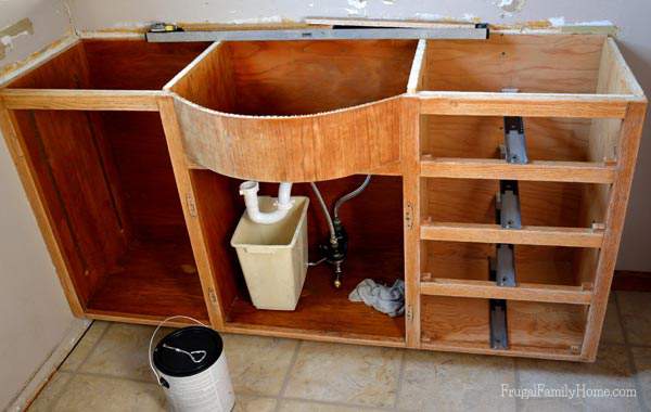 The bathroom vanity with all the varnish sanded off for our bathroom vanity update | Frugal Family Home