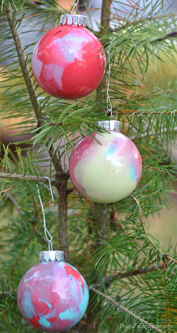 My kids had a great time making this Christmas ornaments, even though I was the one to drop and break one while it was full of paint. We used a glitter paint and watermelon red to make our swirled paint ornaments.