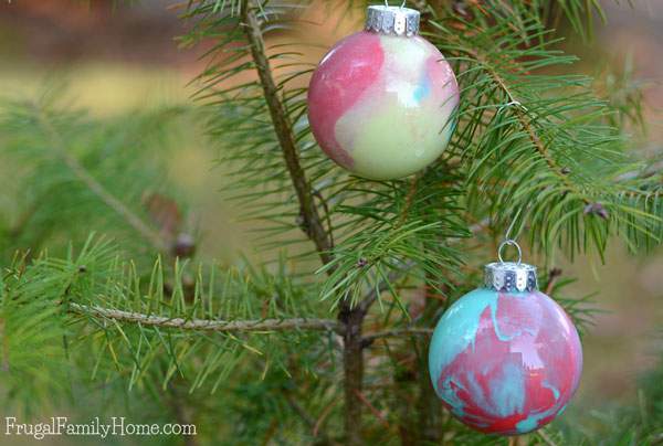 My kids had a great time making this Christmas ornaments, even though I was the one to drop and break one while it was full of paint. We used a glitter paint and watermelon red to make our swirled paint ornaments.