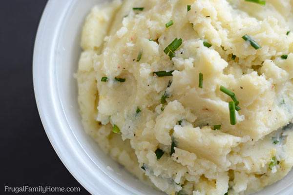 An easy creamy homemade mashed potatoes recipe with garlic and chives. These are so delicious and they can be made ahead and reheated when it’s time to serve.