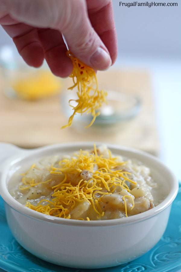 Sprinkle the cheese on the creamy potato soup recipe.