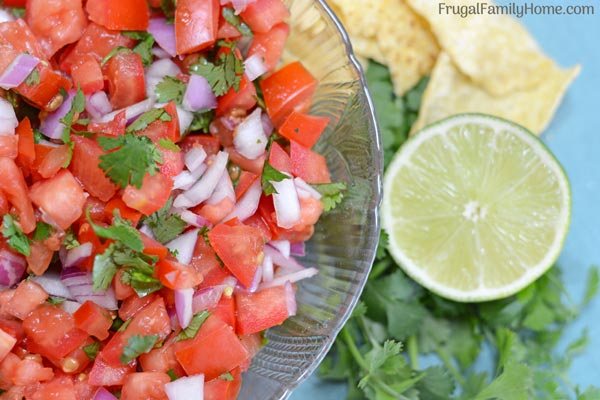 bowl of fresh salsa upclose with a lime.