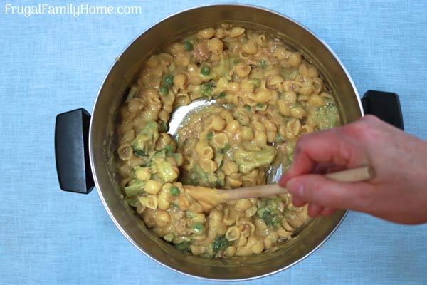 Stirring the cheesy tuna casserole before baking.