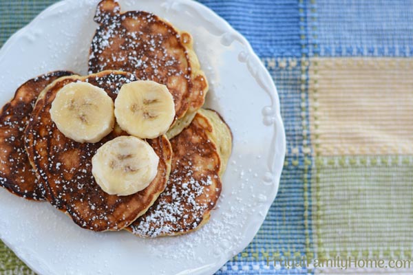 The easy banana pancakes on a plate ready to serve with bananas on top.