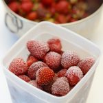 fresh strawberries frozen in freezer container