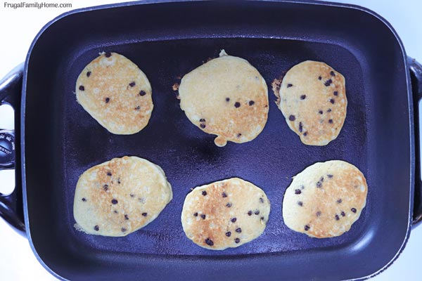 Chocolate Chip pancakes cooking in a pan. 