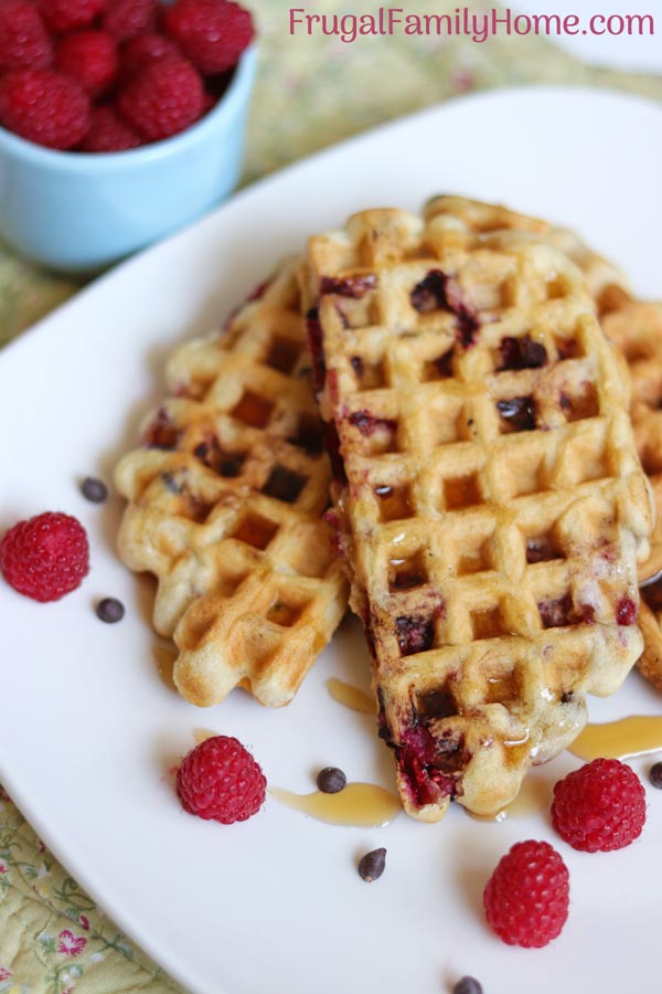 Fluffy waffles from scratch with syrup, raspberries and chocolate chips