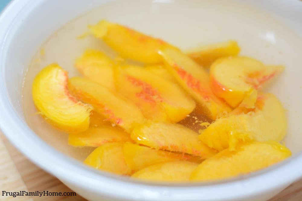 Sliced peaches soaking before freezing them.