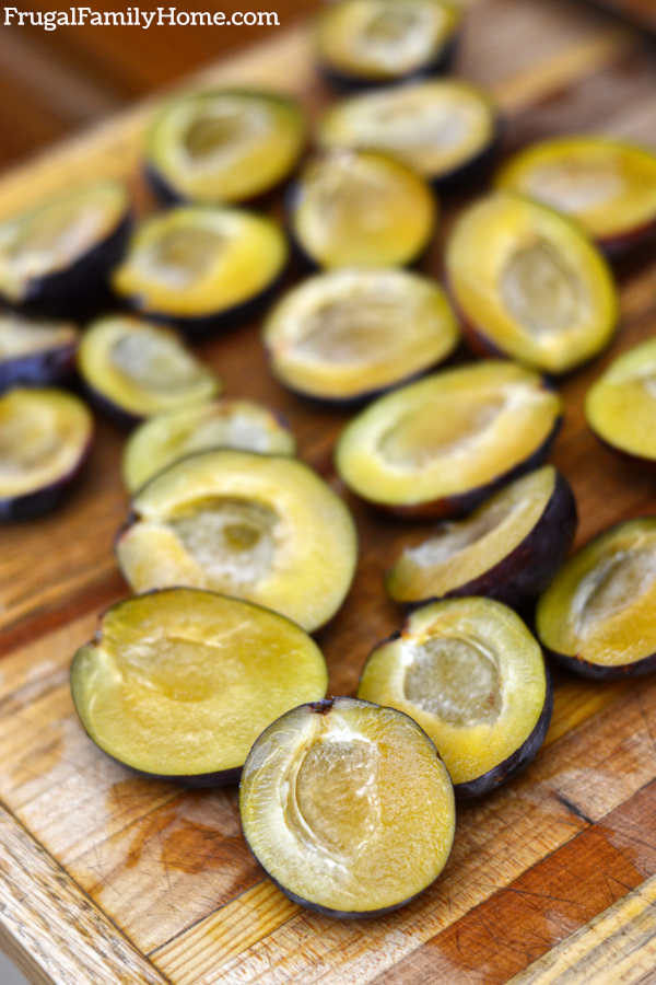 Plums cut in half and ready to dry