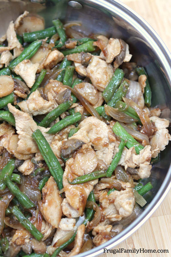 chicken and green beans in a skillet cooked for dinner.