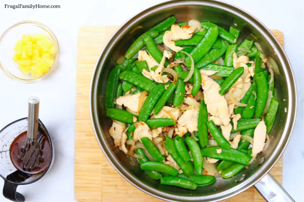 The sugar snap peas in the pan which chicken and onions.