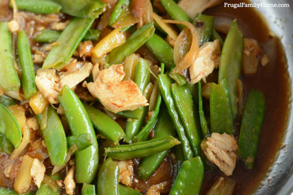 up close of chicken stir fry with peas and pineapple.