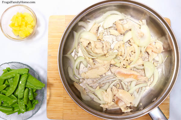 Chicken and onions cooking in the pan.