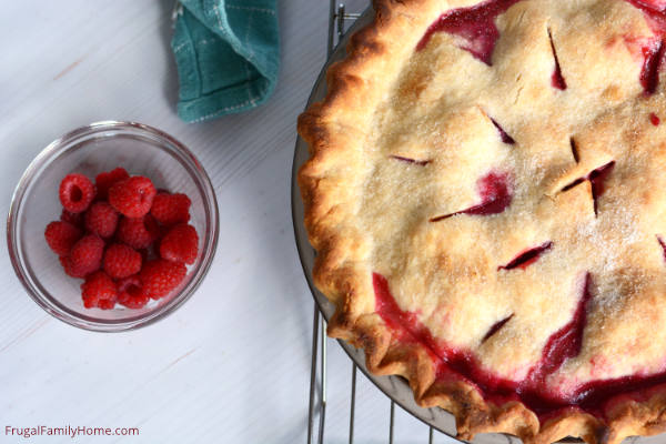 The homemade raspberry pie cooling on a rack