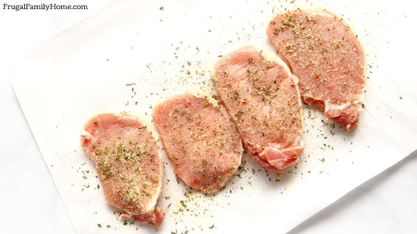 Pork chops sprinkled with rub.