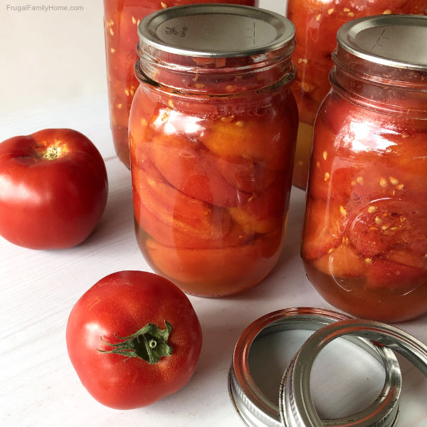 Jars of home canned tomatoes ready to store.