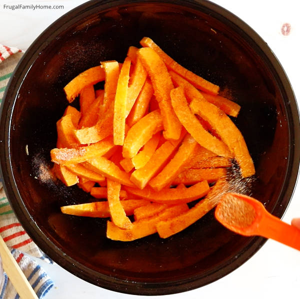 sprinkling the pumpkin fries with seasoning