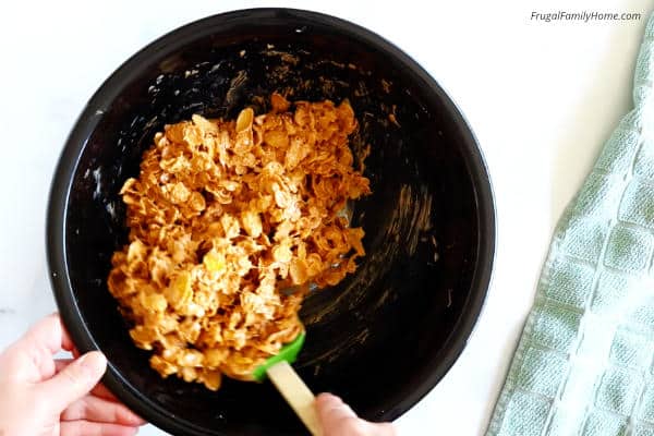 mixing the cornflakes with butterscotch and peanut butter