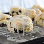 Blueberry Biscuits on cooling rack dripping with lemon glaze