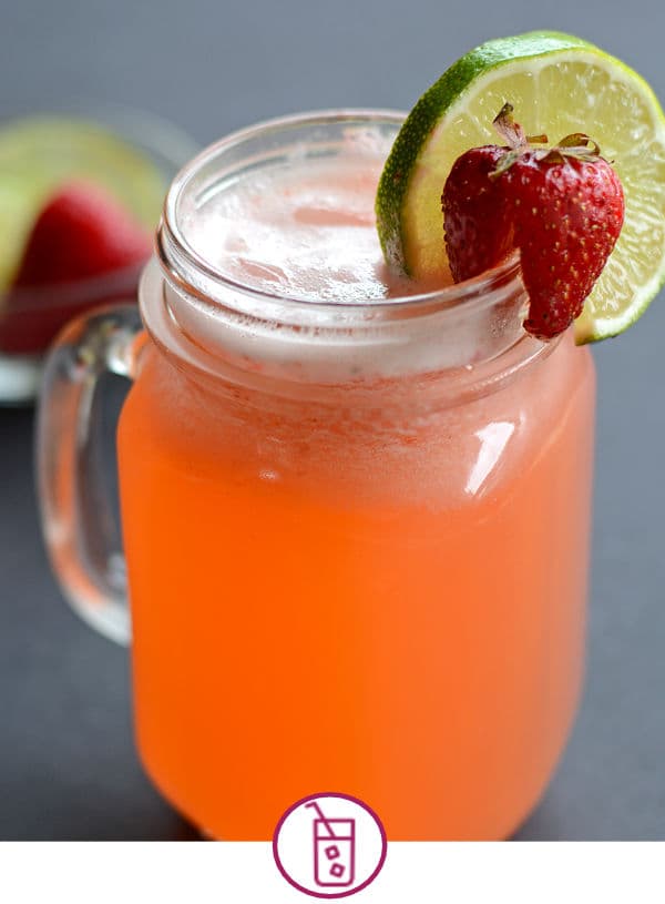 A cool beverage with lime slice and strawberry in a mason jar