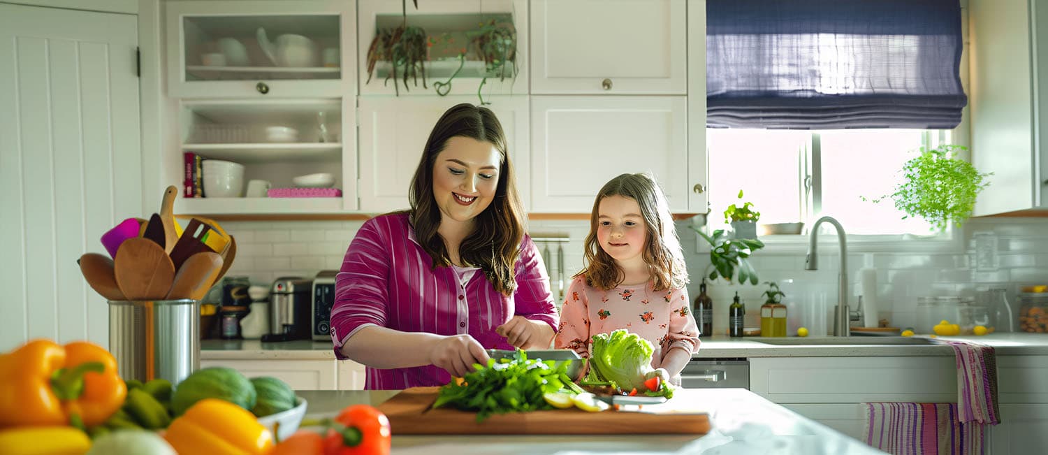 Mom and child at a kitchen counter chopping vegetables