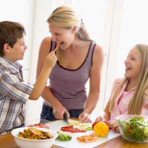 Mom with son and daughter cutting vegetables