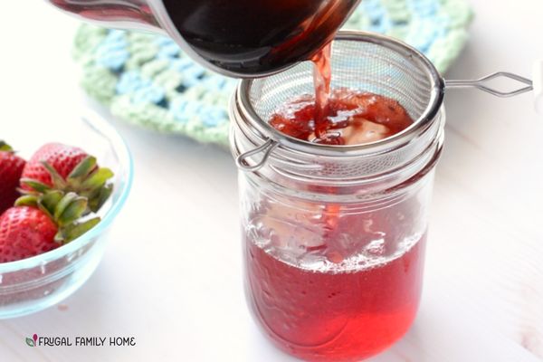 Straining the last bit of strawberries out of the simple syrup.